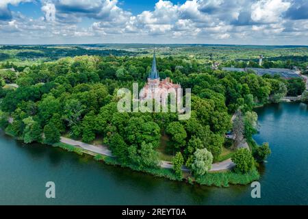 Palast Tyszkiewicz (Herrenhaus Tiskeviciai) in Lentvaris an der Küste des Sees, Litauen. Luftaufnahme der Burg im Tudor-Stil Stockfoto