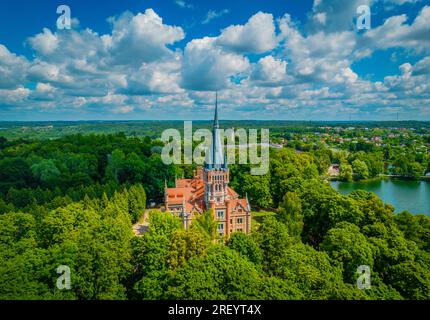 Palast Tyszkiewicz (Herrenhaus Tiskeviciai) in Lentvaris an der Küste des Sees, Litauen. Luftaufnahme der Burg im Tudor-Stil Stockfoto