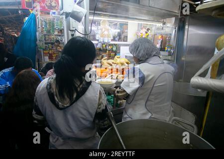 Cusco, Peru; 1. Januar 2023: Kommerzielle Aktivität mit lokalen Lebensmittelverkäufern auf dem Lebensmittelmarkt von San Pedro in Cusco. Stockfoto