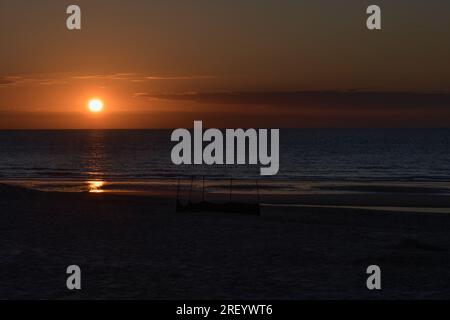 Landschaft Sonnenuntergang auf dem Meer. Fast dunkler verlassener Sandstrand. Platz für Text Stockfoto