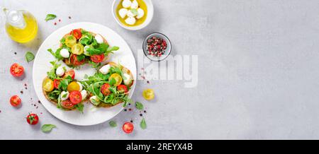 Bruschetta mit Kirschtomaten, Mini Mozzarella Käse und Pesto Sauce, Caprese Toasts, leckerer Snack Stockfoto