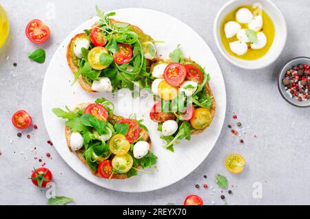 Bruschetta mit Kirschtomaten, Mini Mozzarella Käse und Pesto Sauce, Caprese Toasts, leckerer Snack Stockfoto