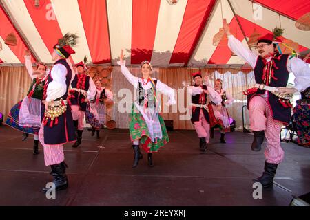 Kostümierte Teilnehmer einer historischen Nachstellung eines polnischen Erntefests führen in einer katholischen Kirche in Yorba Linda, Kalifornien, ethnische Tänze auf. Stockfoto