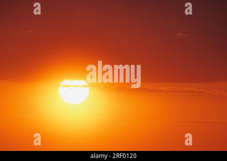 Der spektakuläre Blick auf den Sonnenuntergang war atemberaubend, mit der Sonne, die hinter den Wolken am Horizont versinkt. Stockfoto