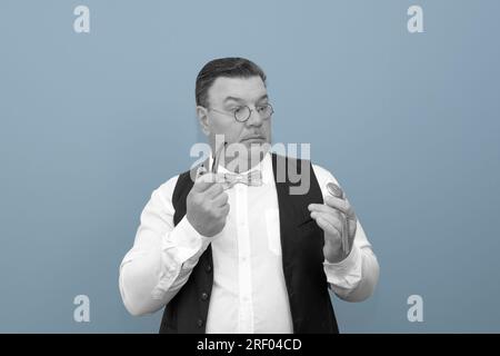 Die Zeit ist um. Komisches Retro-Phantombild eines Mannes. Taschenuhr in der Hand, Raucherpfeife, Fliege. Stockfoto