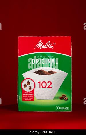 Salvador, Bahia, Brasilien - 30. Juli 2023: Papierfilterverpackung der Marke Melitta zum Absieben von Kaffee, isoliert auf rotem Hintergrund. Stockfoto