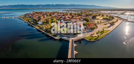 Nin, Kroatien - Panoramablick aus der Vogelperspektive auf die historische Stadt und die kleine Insel Nin mit traditionellen Salz-Stillfeldern und dem blauen Adriatischen Meer bei Sonne Stockfoto