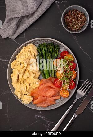 Fotografie des Frühstücks, Rührei; Brunch; Omelette; geräuchert; Lachs; Brokkoli, Tomaten, Kresse, Salat, Hintergrund Stockfoto