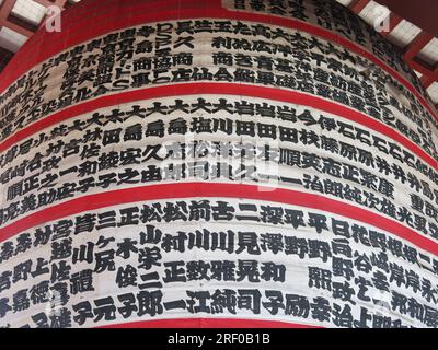 Nahaufnahme des japanischen Schriftzugs auf der riesigen Laterne des Senso-ji Tempels, einer buddhistischen religiösen Stätte und den zehn beliebtesten Touristenzielen in Tokio. Stockfoto