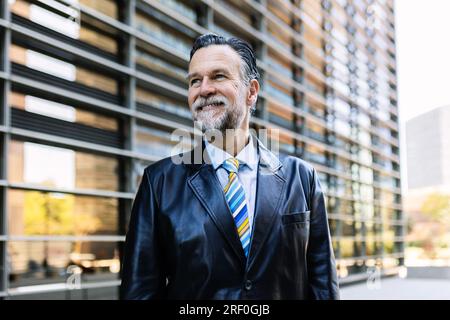 Fröhliches Porträt eines lächelnden Senior-Geschäftsmanns, der draußen steht Stockfoto