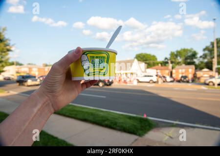 Eine Tasse Ted Drewes Eiscreme mit dem Gebäude im Hintergrund. Ted Drewes ist ein Familienunternehmen für gefrorene Vanillesauce in St. Louis, Missouri, Uno. Stockfoto