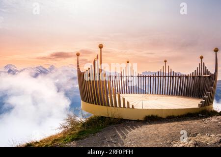 Aussichtspunkt auf dem Gipfel des Mannlichen Berges bei Lauterbrunnen und Grindelwald, Schweiz, bei Sonnenuntergang. Schneebedeckte Gipfel der Schweizer Alpen in niedrigen Wolken Stockfoto