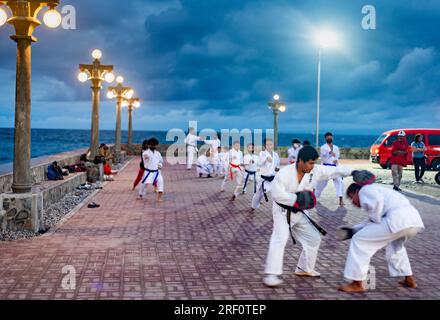 Dumaguete, Negros Island, Philippinen-Januar 29 2023: Ein lokaler philippinischer Karate clube verfeinert ihre Fähigkeiten draußen, nach Sonnenuntergang, am Dumagute's Wasser Stockfoto