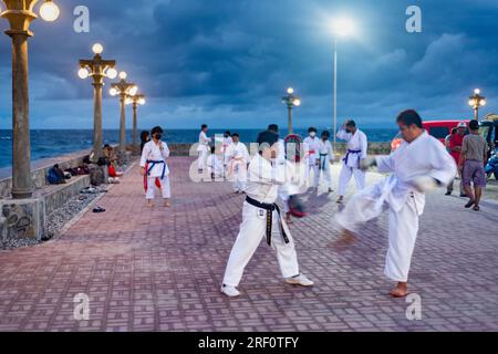 Dumaguete, Negros Island, Philippinen-Januar 29 2023: Ein lokaler philippinischer Karate clube verfeinert ihre Fähigkeiten draußen, nach Sonnenuntergang, am Dumagute's Wasser Stockfoto