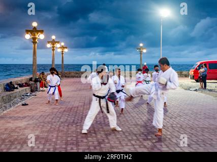 Dumaguete, Negros Island, Philippinen-Januar 29 2023: Ein lokaler philippinischer Karate clube verfeinert ihre Fähigkeiten draußen, nach Sonnenuntergang, am Dumagute's Wasser Stockfoto