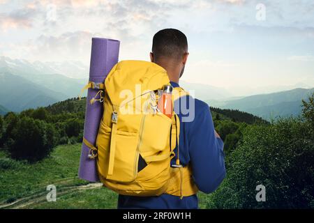 Tourist mit Rucksack in den Bergen, Rückblick Stockfoto