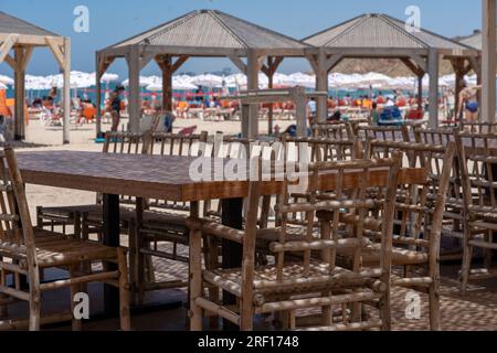 TEL AVIV, ISRAEL - JULI 21: Tische und Stühle im Restaurant am Strand von Tel Baruch am 21. Juli 2023 in Tel Aviv, Israel. Stockfoto