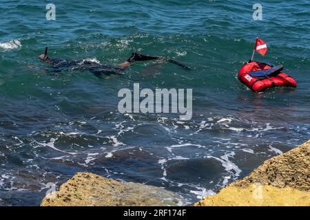 TEL AVIV, ISRAEL - JULI 21: Ein Mann schnorchelt am Wellenbrecher am Tel Baruch Beach am 21. Juli 2023 in Tel Aviv, Israel. Stockfoto