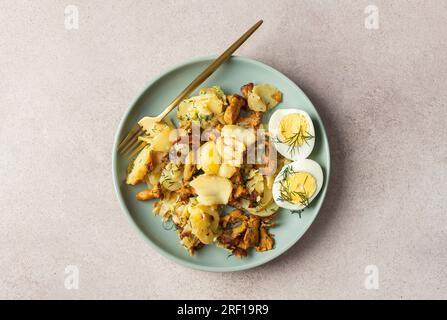 Köstliche herzhafte Abendessen oder Mittagessen, gebratene junge Kartoffeln mit Waldpilzen Chanterelles mit Dill, gekochte Eier, saisonale Speisen Stockfoto