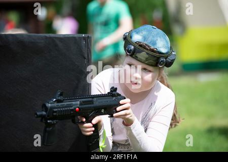 Belarus, Dorf Yagodnaya, 27. Mai 2021. Kinderurlaub. Ein Mädchen mit einer Laserwaffe spielt Laser-Tag. Stockfoto