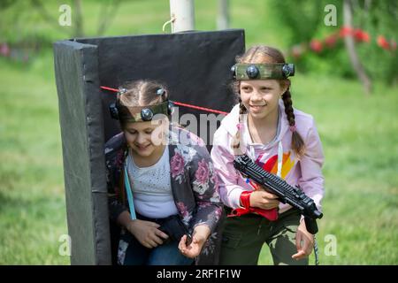 Belarus, Dorf Yagodnaya, 27. Mai 2021. Kinderurlaub. Mädchen mit Laserwaffen spielen Laser-Tag. Stockfoto