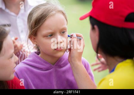 Der Make-up-Künstler zeichnet das Gesicht eines Kindes. Stockfoto