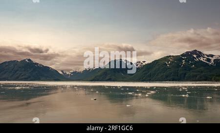 Natürliche Meereslandschaft an der Bergküste. Die Natur des Hubbard-Gletschers in Alaska, USA. Malerischer Blick auf grüne Berghänge mit schneebedeckten Berggipfeln, Gletschereis Stockfoto