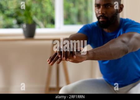 Fokussierter afroamerikanischer Mann, der zu Hause trainiert Stockfoto
