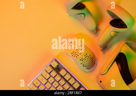 Gaming-Zubehör und Tastatur auf orangefarbenem Schreibtisch Stockfoto