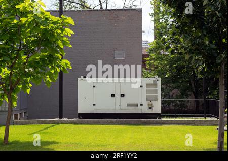 Zusätzlicher Dieselgenerator für die Notstromversorgung. Industrieller Generator, der über einen Kabeldraht mit der Zentrale verbunden ist. Notstromversorgung des Stockfoto