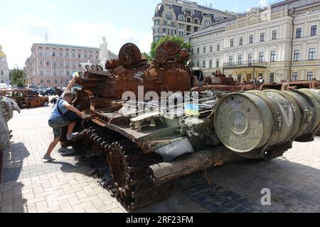 Auf einem Platz im Zentrum von Kiew, Ukraine, wird ein Junge auf einem veresterten russischen Armeepanzer ausgestellt Stockfoto