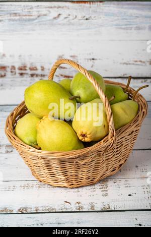 Frische Birnen in einem Korb aus Weidenholz auf Holzhintergrund. Konzept der Birnenernte. Gesundes und frisches Obst Stockfoto