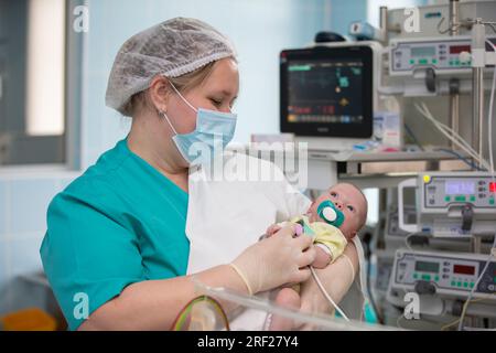 31. Mai 2021. Weißrussland, Gomil. Neugeborenen-Intensivstation. Der Arzt hält ein neugeborenes Kind in seinen Armen vor dem Hintergrund von Medizinprodukten. Stockfoto