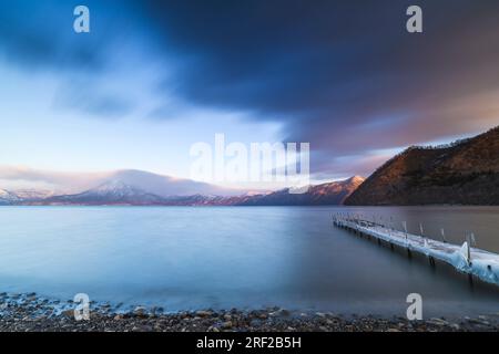 Lange Belichtungszeit von einem mit Eis bedeckten Bootssteg am Shikotsu-See in Hokkaido, Japan Stockfoto