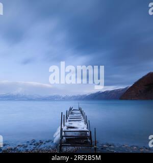 Lange Belichtungszeit von einem mit Eis bedeckten Bootssteg am Shikotsu-See in Hokkaido, Japan Stockfoto