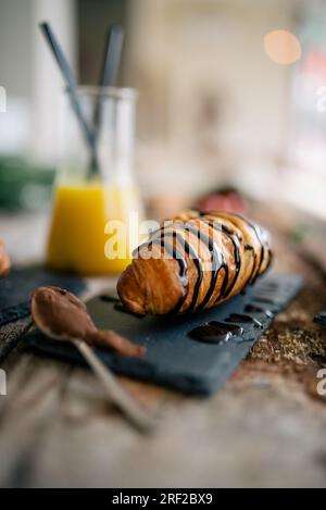 Croissant zum Frühstück auf einem rustikalen Holztisch in einem Restaurant. Stockfoto