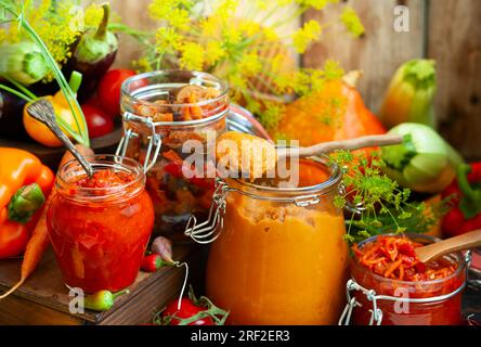 Im Herbst hausgemachtes Gemüse in Glasgefäßen - Ajvar, Kürbiskaviar, Ratatouille, eingelegte Karotten. Konzept für vegetarische Speisen im Herbst, Kopie s Stockfoto