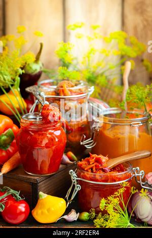 Im Herbst hausgemachtes Gemüse in Glasgefäßen - Ajvar, Kürbiskaviar, Ratatouille, eingelegte Karotten. Konzept für vegetarische Speisen im Herbst, Kopie s Stockfoto