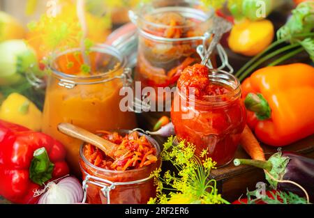 Im Herbst hausgemachtes Gemüse in Glasgefäßen - Ajvar, Kürbiskaviar, Ratatouille, eingelegte Karotten. Konzept für vegetarische Speisen im Herbst, Kopie s Stockfoto