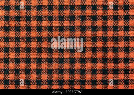 Die Textur von Leinengewebe in einer großen Zelle aus Schwarz und Braun. Schottisches Schneidermaterial. Karierter Stoff Stockfoto