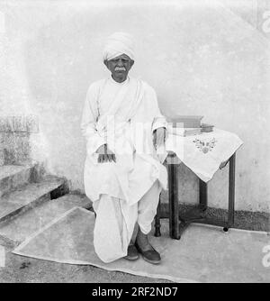 Altes, klassisches 1900er Schwarz-Weiß-Studiobild eines älteren Indianers mit Dhoti Kurta Turban Gujarat India Stockfoto