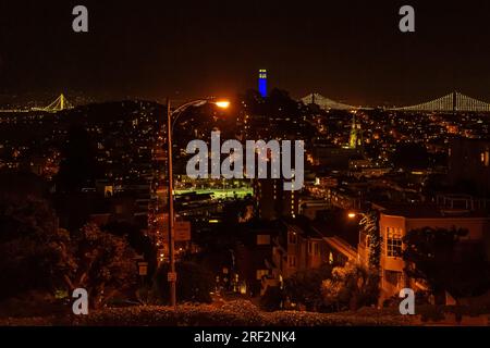 San Francisco Stadtbild bei Nacht Panorama. Blick auf den Coit Tower bei Nacht, vom Russian Hill in San Francisco. San Francisco Coit Tower in Blau für den Sieg der Krieger beleuchtet. Stockfoto