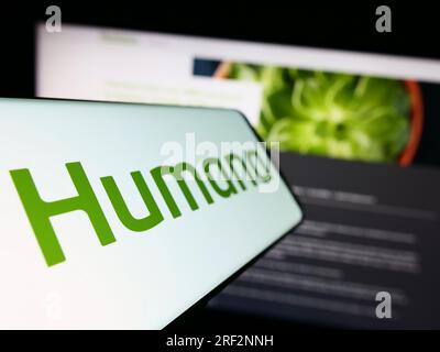 Handy mit Logo der amerikanischen Krankenversicherung Humana Inc. Auf dem Bildschirm vor der Business-Website. Fokus auf der linken Seite des Telefondisplays. Stockfoto