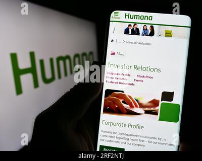 Person mit Smartphone und Webseite der US-Krankenversicherung Humana Inc. Auf dem Bildschirm vor dem Logo. Konzentrieren Sie sich auf die Mitte des Telefondisplays. Stockfoto