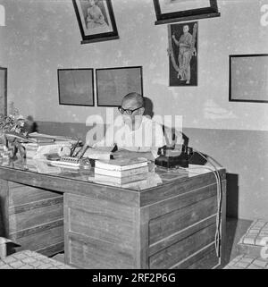 Altes Schwarz-Weiß-Bild aus dem Jahr 1900er von einem indischen Mann mit Schreibtisch und Wähltelefon India 1940er Stockfoto