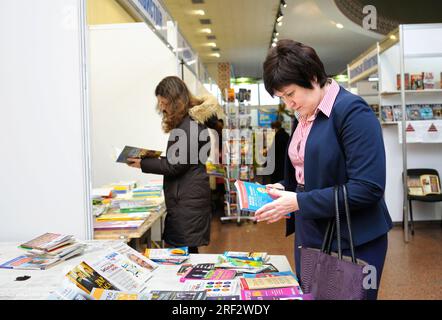 Weibliche Käufer stehen vor einer Buchhandlung und lesen neue Bücher. Buchmesse. 14. Dezember 2017. Kiew, Ukraine Stockfoto