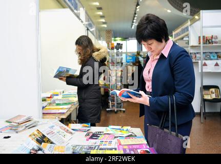 Weibliche Käufer stehen vor einer Buchhandlung und lesen neue Bücher. Buchmesse. 14. Dezember 2017. Kiew, Ukraine Stockfoto