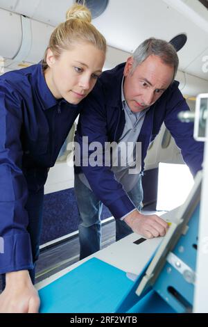 flugzeugingenieur und Auszubildender, die an Flugzeugen arbeiten Stockfoto