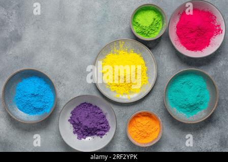 Draufsicht des bunten traditionellen holi Pulvers in Schalen auf grauem Hintergrund. Frohes holi. Bereich Kopieren. Das Konzept des indischen Farbfestivals. Stockfoto