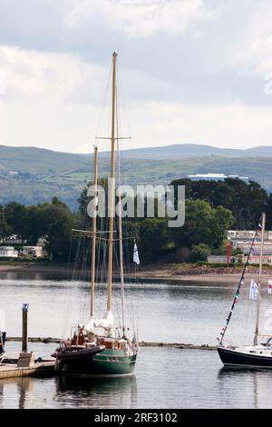 Yacht liegt im Yachthafen Rhu in Gareloch vor, mit Rosunder Penisula und Karawane im Hintergrund, Schottland Stockfoto